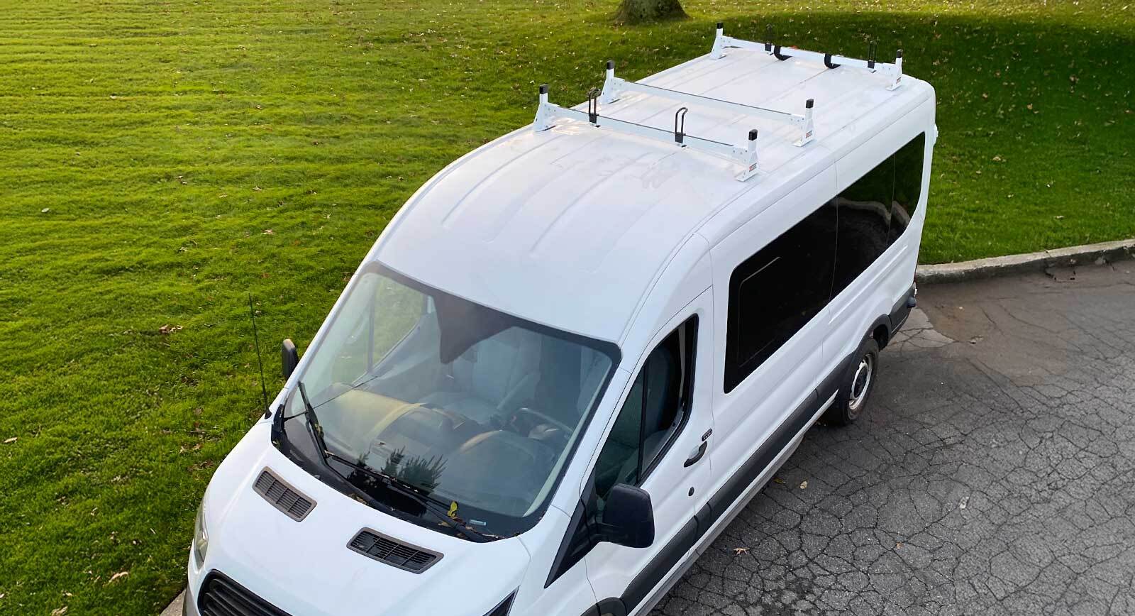 White commercial van with a roof-mounted cargo rack system for carrying large items