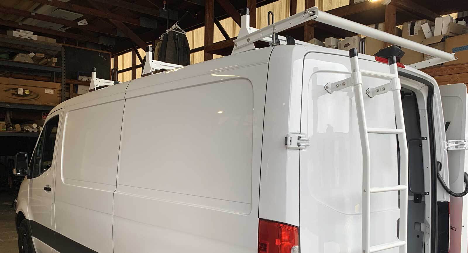 White commercial van with a clamp down ladder mounted on the back door